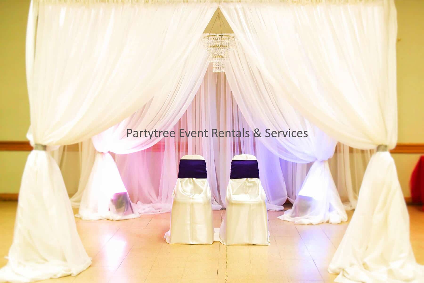 elegant sashes with colourful lighting featuring two covered chairs accented by purple sashes