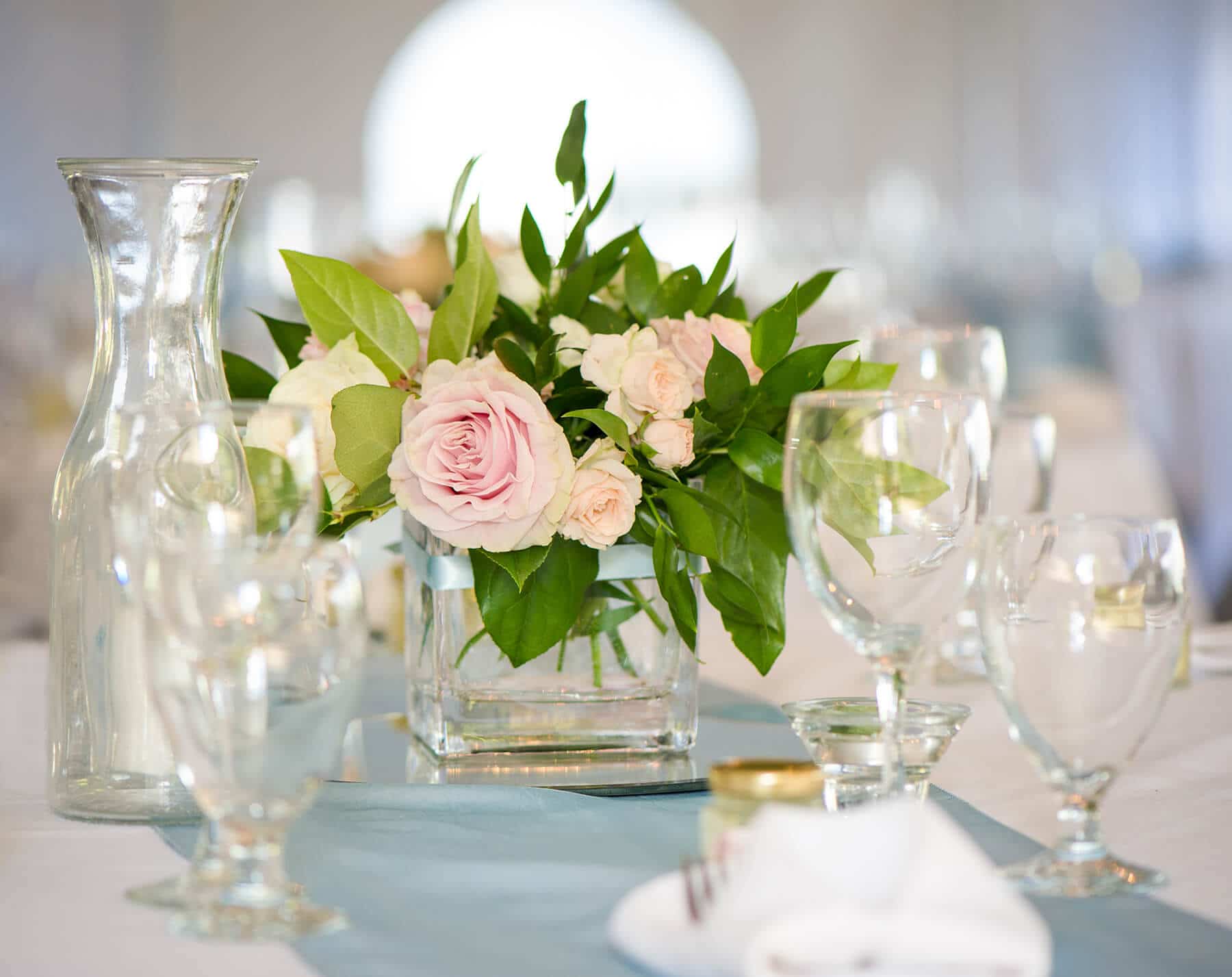 pink rose centre piece wth wine glasses and decanters at the ready